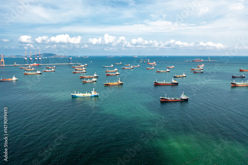 Aerial view of numerous oil and gas tankers anchored in a bay, showcasing industrial-scale maritime energy transport and the density of commercial sea traffic.