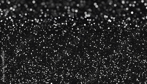 Abstract design of black surface with glittering particles.