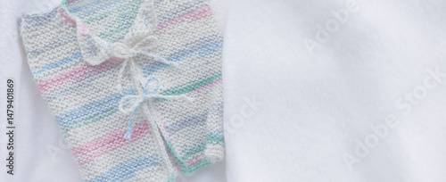 Gestricktes weisses Babyjäckchen auf weissem Hintergrund