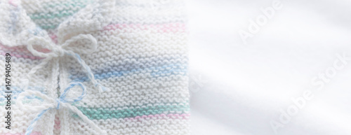 Gestricktes weisses Babyjäckchen auf weissem Hintergrund