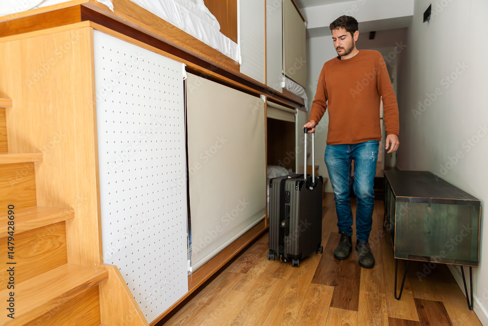 Fototapeta premium Modern hostel with cozy minimalist dorms, wooden capsule beds, and peaceful courtyard. Men chatting and relaxing in a quiet neighbourhood