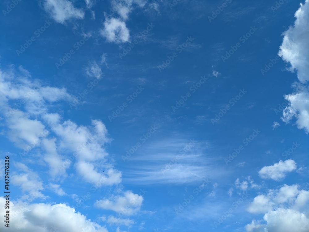 Naklejka premium Blue Skies with wispy lines and fluffy white clouds
