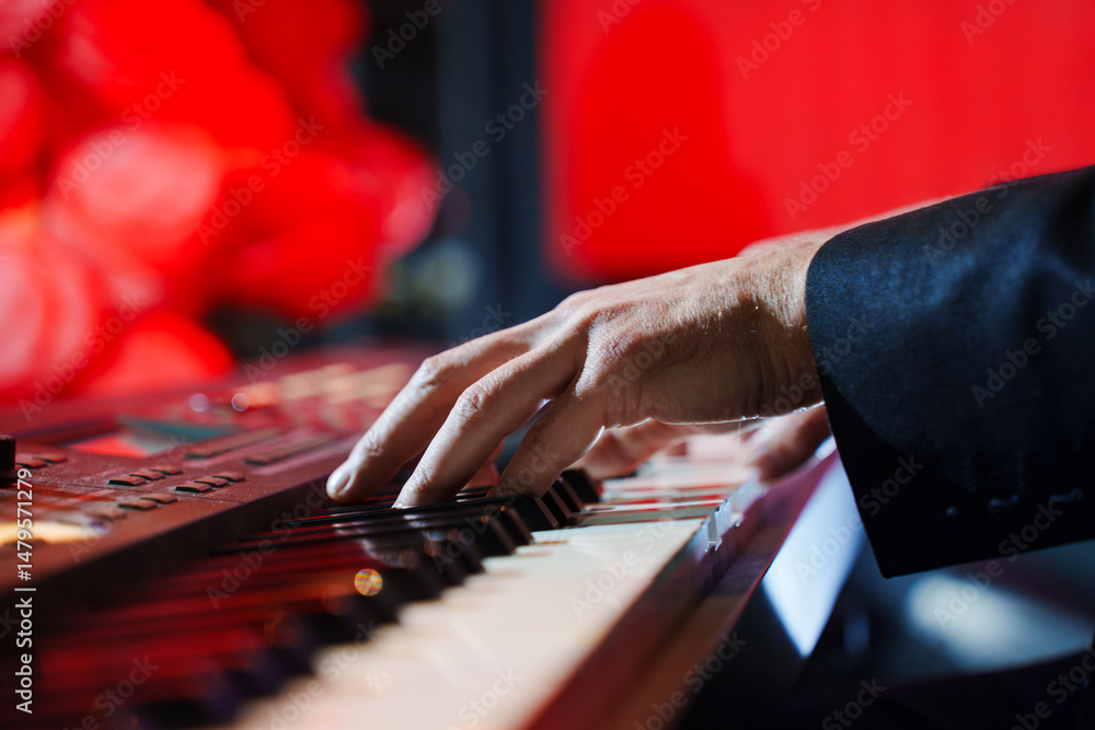 Obraz premium Men's hands play the keys of an electronic piano.