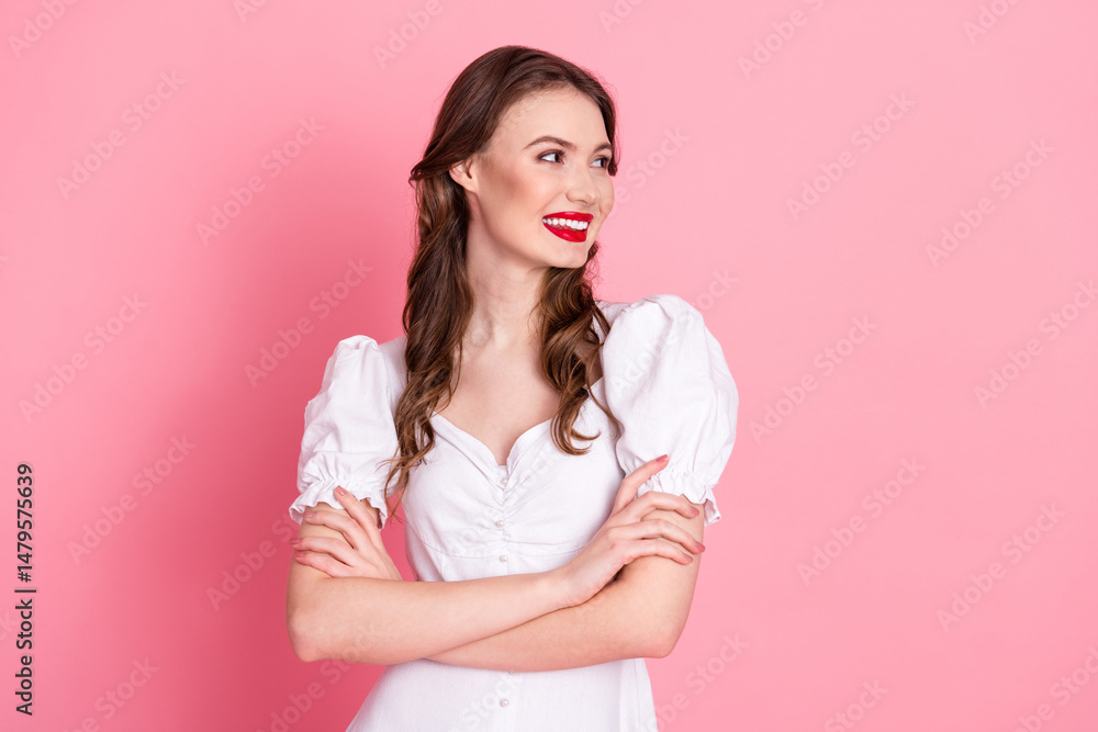 Charming young woman in a white dress smiling confidently in front of a vibrant pink background Charming young woman in a white dress smiling confidently in front of a vibrant pink background