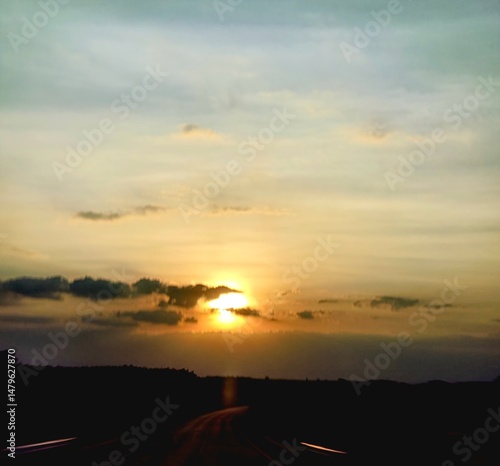 Silhouetted Road Under Bright Sky

