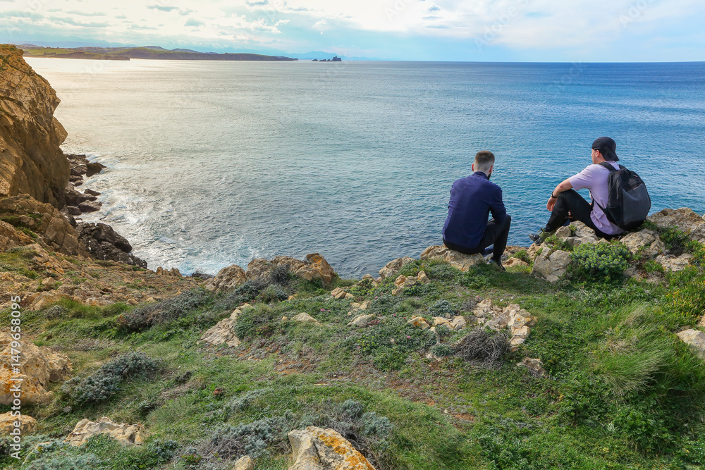 Fototapeta premium Two people walking through the landscape of the Costa Quebrada in Cantabria