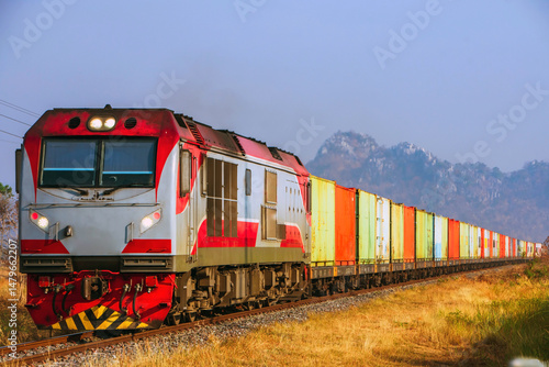 Locomotive with cargo containers on the railway, Thailand.