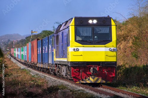 Locomotive with cargo containers on the railway, Thailand.