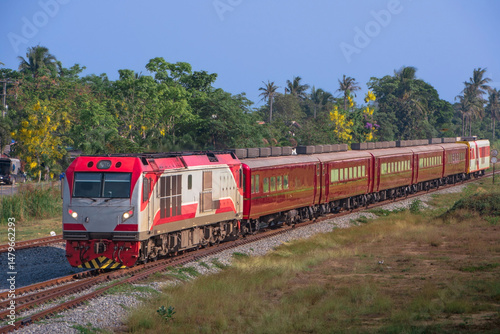 Passenger train by diesel locomotive on the railway in Thailand.