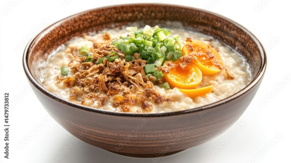 Creamy porridge topped with crispy fried shallots, sliced scallions, and a halved salted egg yolk Creamy porridge topped with crispy fried shallots, sliced scallions, and a halved salted egg yolk