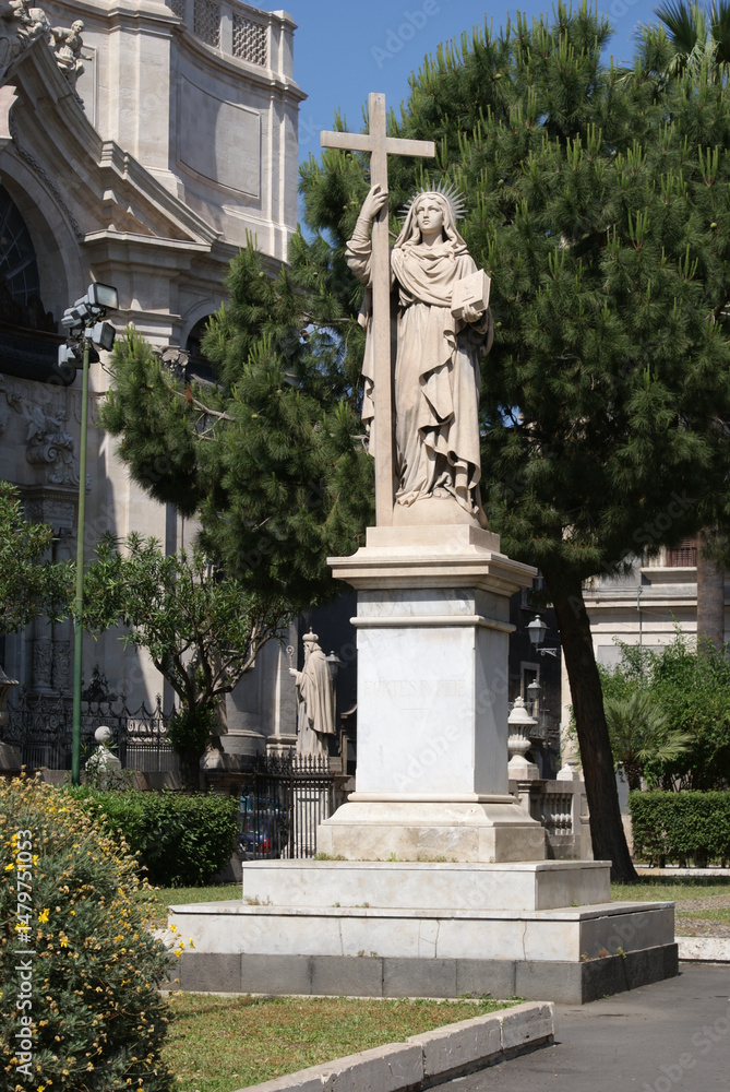 Fototapeta premium 18th century statue of Saint Agatha, holding book and cross in front of Catania Cathedral in Catania, Sicily, Italy