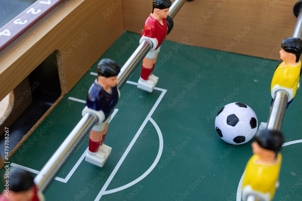 Fototapeta premium A captivating image of a tabletop foosball game in action. Focus on the players and ball.