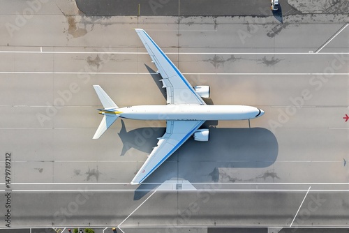 Large airplane viewed from top on airport runway, creative aerial photo, gray concrete background, concept of aviation and travel. Ai generative