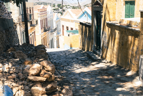 Fototapeta Naklejka Na Ścianę i Meble -  Picturesque alleyway in a Greek village, featuring traditional architecture and cobblestone streets.
