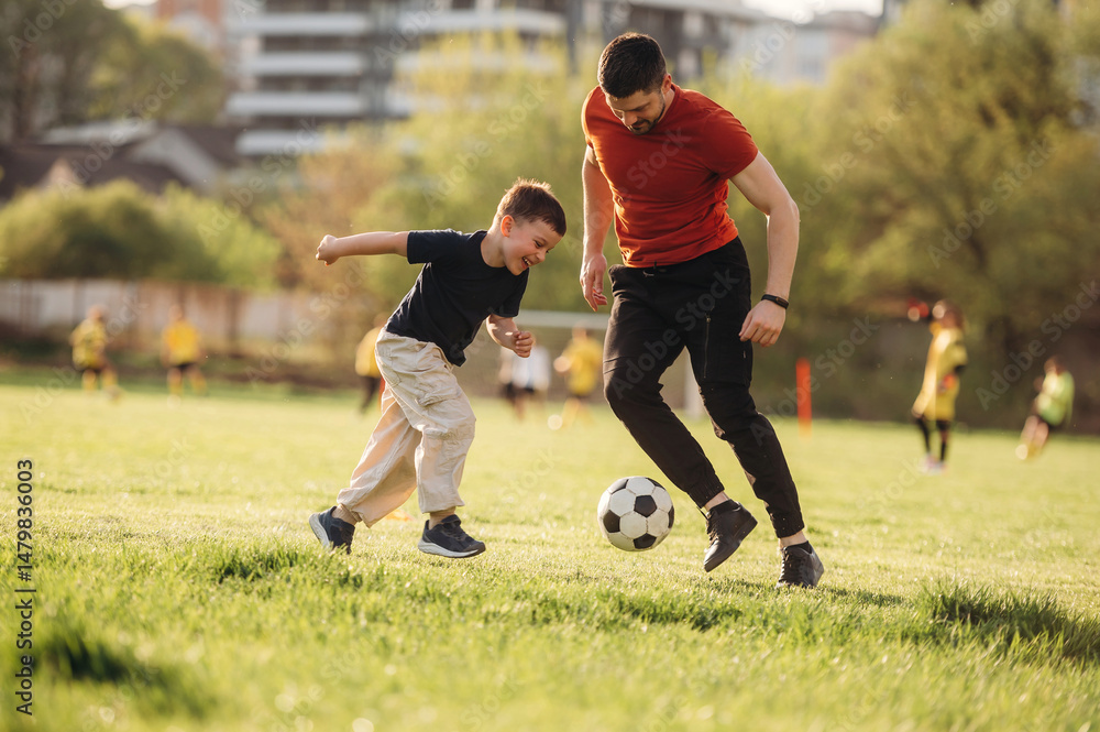 Obraz premium Game of soccer. Father and son are having fun outdoors