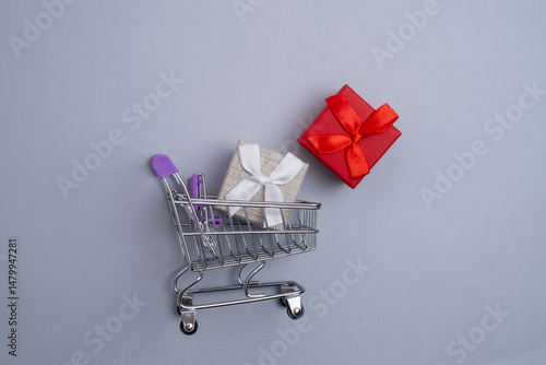 Gift boxes with ribbons in a shopping cart. Time for holidays, sales