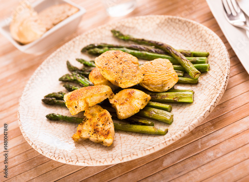 Cooked dish. Chicken nuggets with green asparagus on plate