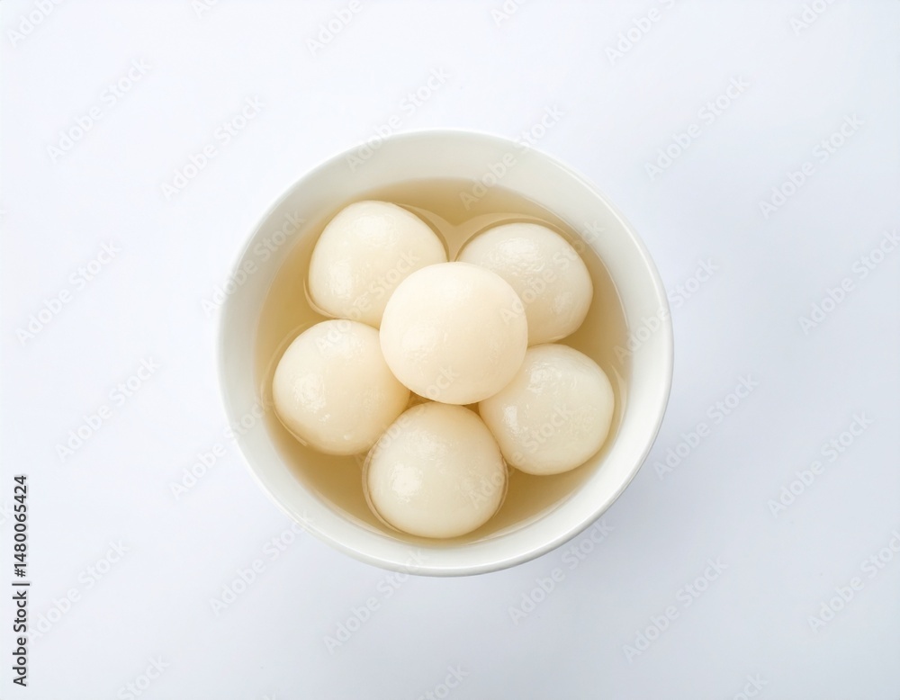 Sweet dumplings in syrup in a white bowl, viewed from above Sweet dumplings in syrup in a white bowl, viewed from above