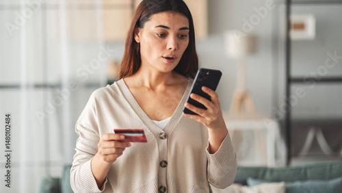 Photos Woman holding credit card and mobile phone in her hand in shock