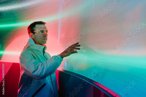 Man looking at the glowing screen using futuristic glasses