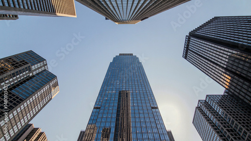 Aerial view of reflective skyscraper buildings with a risque building covered in glass window 