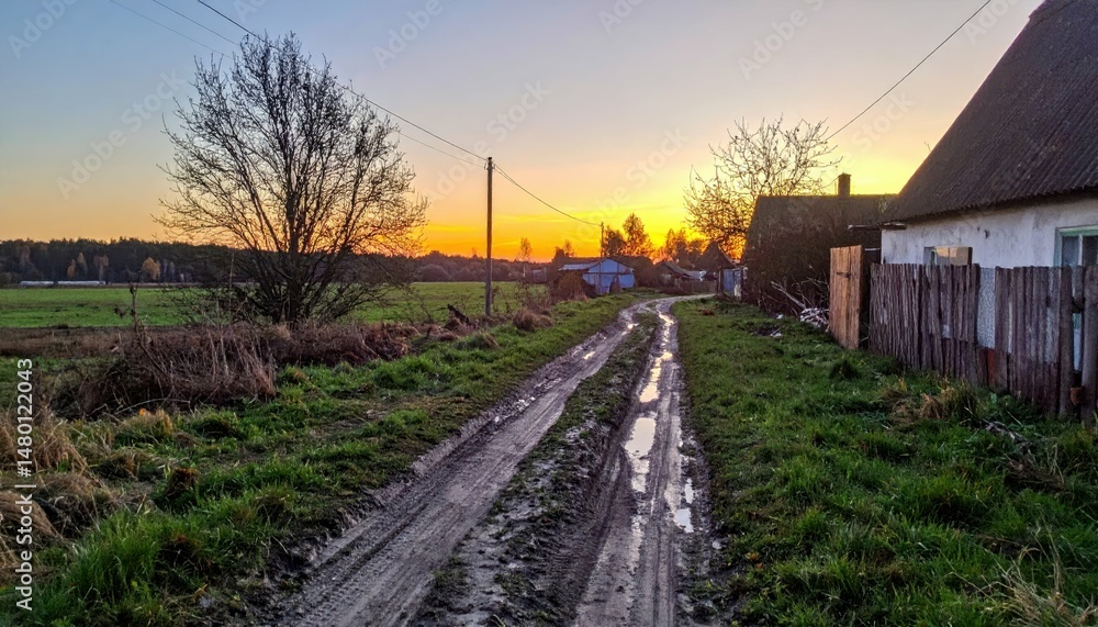 Fototapeta premium Serene Country Road at Sunset with Vibrant Sky and Reflection