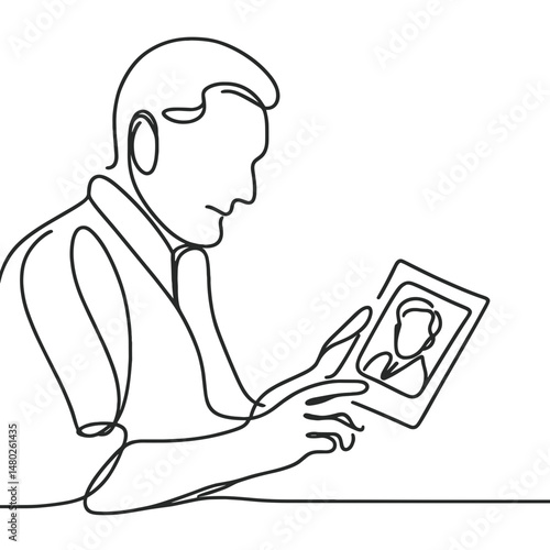 Man holding a framed photo while sitting at a table in a minimal style  