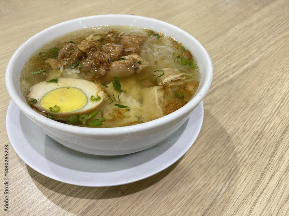 Timlo Soup is Authentic from Solo, Central Java, Indonesian. Made from Chicken, glass noodles, egg, Sosis Solo and Served with hot Clear Chicken Broth. Served on white Bowl.