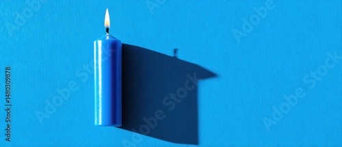 Burning Blue Candle Casting Long Shadow on Turquoise Textured Background Minimalist Still Life Top View
