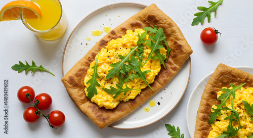 Delicious Scrambled Eggs With Arugula on a Crusty Flatbread Served For Breakfast
