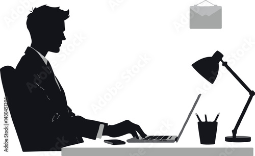 Businessman working late at desk with laptop and desk lamp  