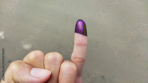 фотографія Close-up photo of a pinkie finger with a purple ink stain, symbolizing voter participation, identity verification, or marking