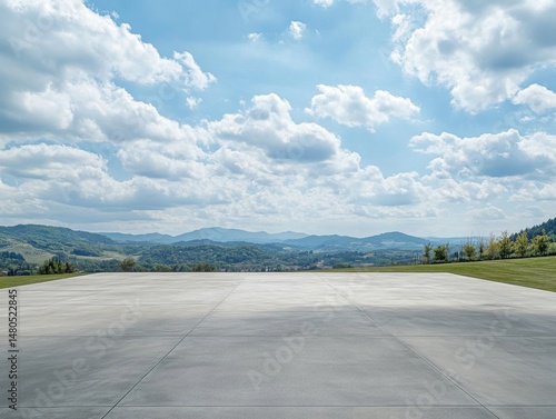 A large outdoor concrete floor with green hills in the background, an open space for car parking or sports activities, a modern minimalist architectural style with a roof, a light blue sky with white 