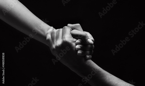 Strong connection. Unrecognizable woman hand helping man to stand up on background, black and white