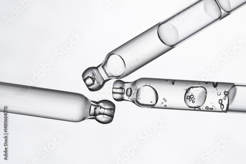 Three droppers of transparent serum, peptide on a light transparent background macro.