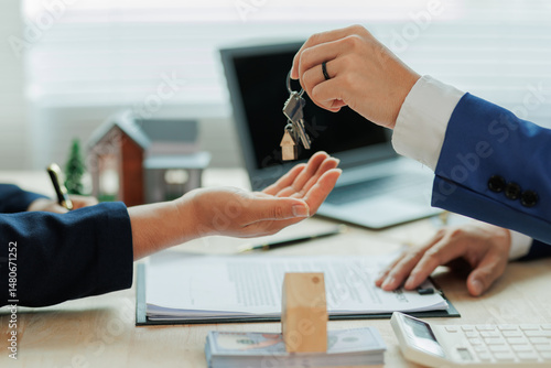 Obraz na płótnie Client pays the agent, who hands over the house keys, marking the official closing and completion of the real estate transaction. w salonie