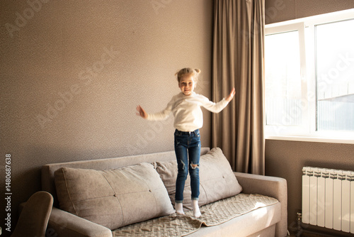 Εκτύπωση καμβά 4 years old blonde girl joyfully jumps on couch at home, giggling with excitement