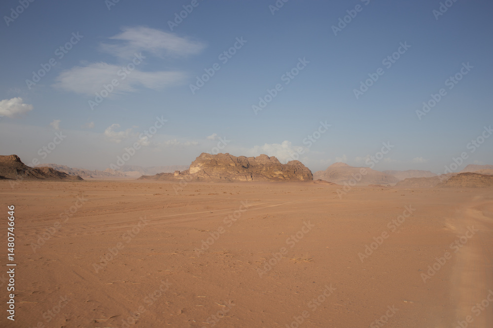 Fototapeta premium Rocky hillside against a clear blue sky. The sky is very bright, and the sun is shining. The desert is very hot for life, ecology, the heat is very high, there is no vegetation