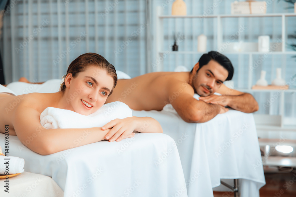 Obraz premium Caucasian couple customer enjoying relaxing anti-stress spa massage and pampering with beauty skin recreation leisure in day light ambient salon spa at luxury resort or hotel. Quiescent