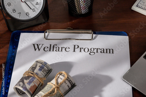 A government welfare program document held in a clipboard, placed neatly on a wooden desk.

