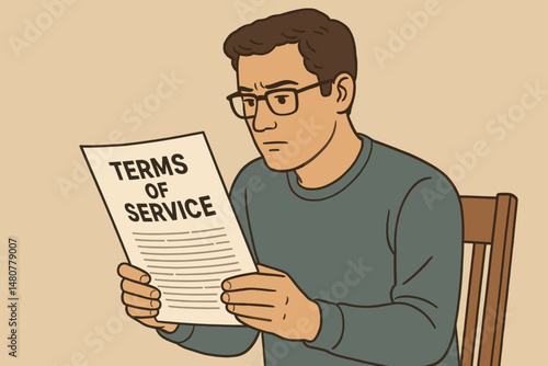 Man reading terms of service while sitting in a chair indoors  