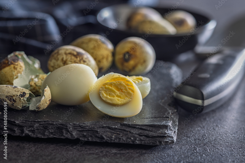 Boiled quail eggs on black table.