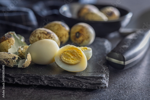 Boiled quail eggs on black table.