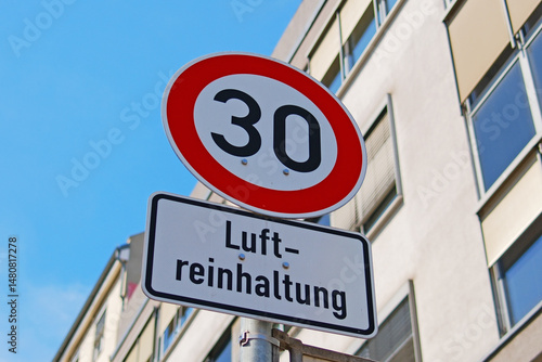 Tempolimit 30 zur Luftreinhaltung – Verkehrsschild in deutscher Stadt bei blauem Himmel