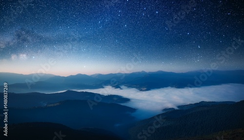 View of beautiful night sky with stars in foggy mountain valley.