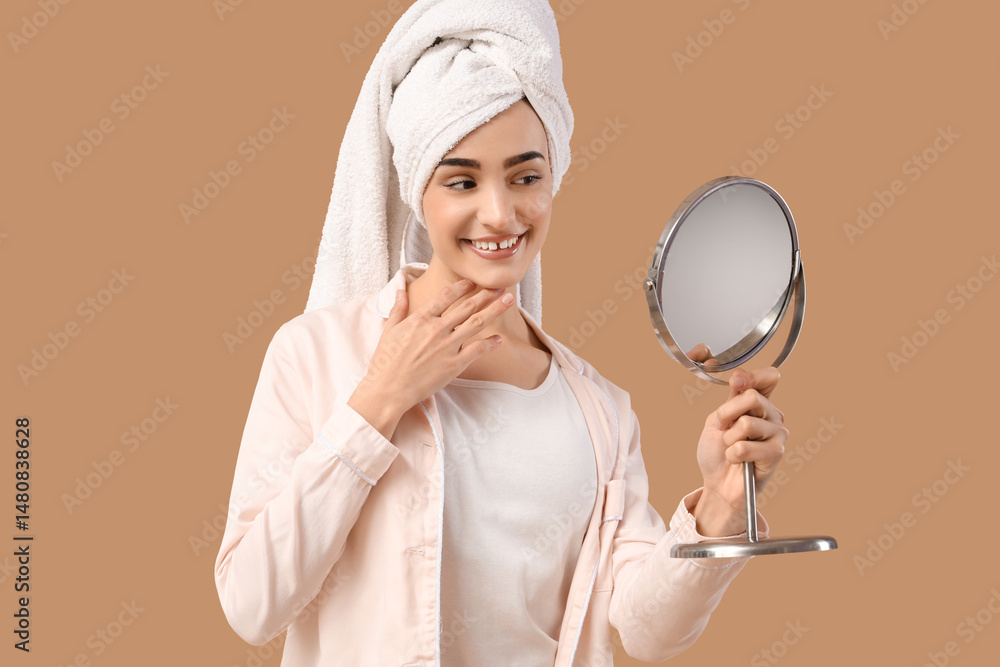 Young woman looking in mirror after shower on beige background Young woman looking in mirror after shower on beige background
