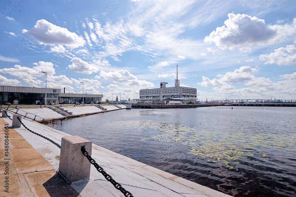 Fototapeta premium Urban Waterfront With Modern Building Under Bright Blue Sky..