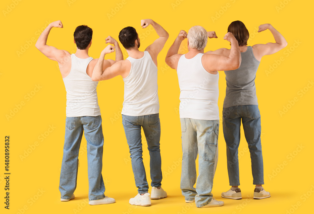 Fototapeta premium Group of men showing muscles on yellow background, back view. Body positive concept