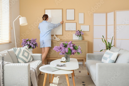 Young woman hanging blank f...