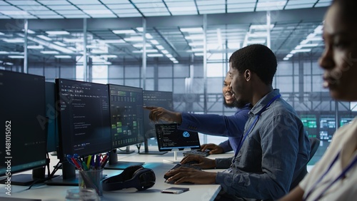 Cheerful coworkers in data center implementing AI predictive maintenance systems. Server room engineers using artificial intelligence to identify hardware failures impacting operations, camera A